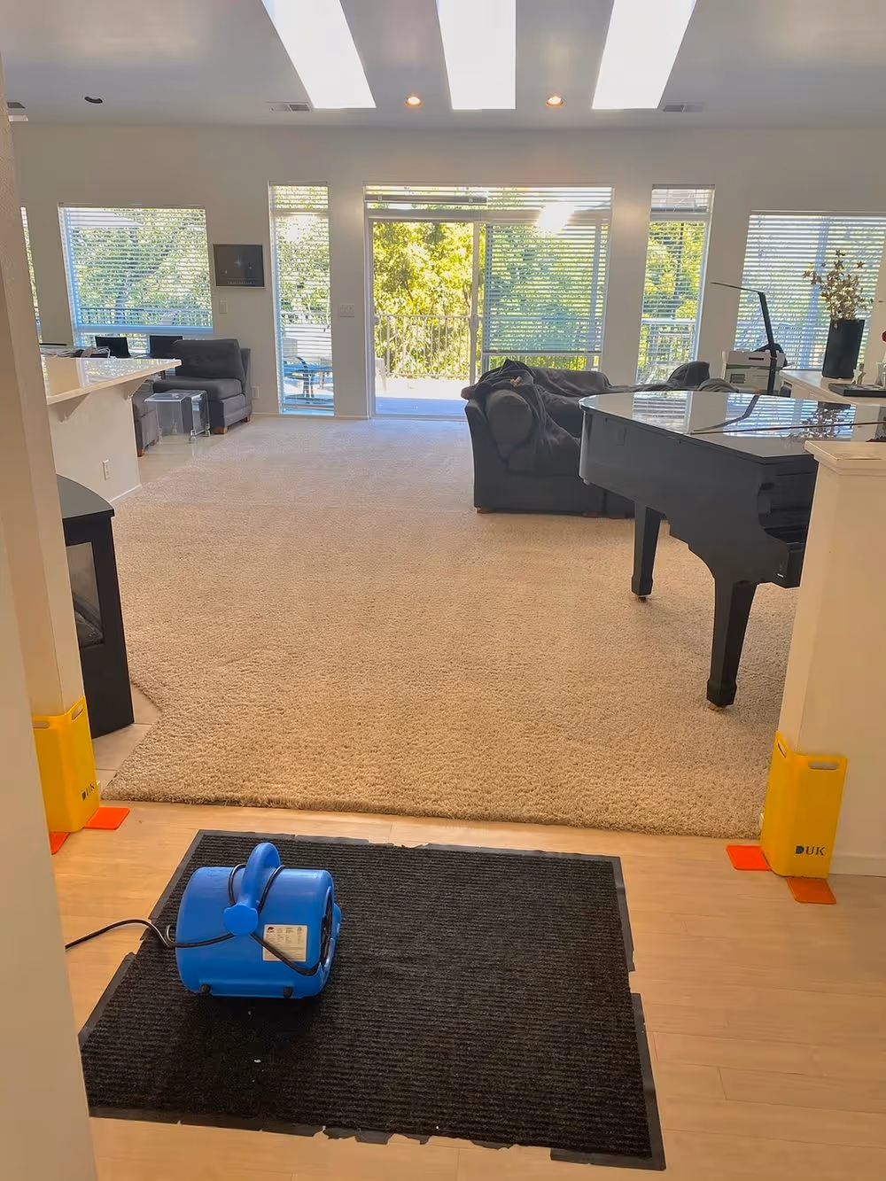 An air mover placed on a mat in a great room during drying