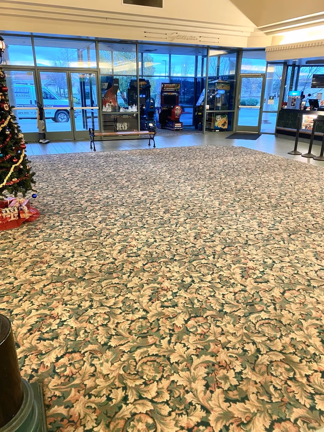 A large commercial floor after cleaning, with the entrance doors beyond