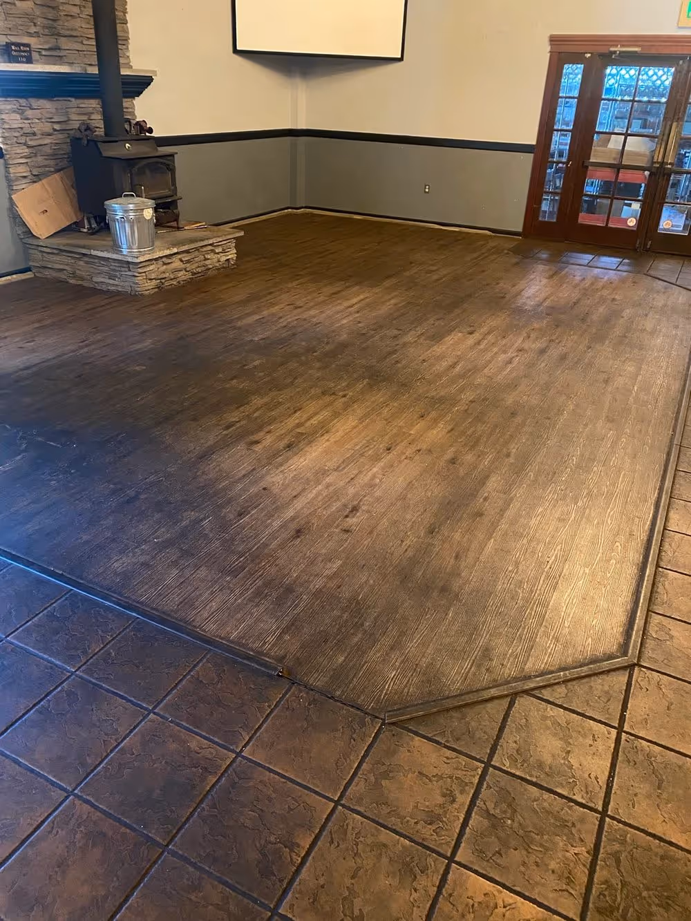 Dark hardwood meeting a tile border, both cleaned and refinished