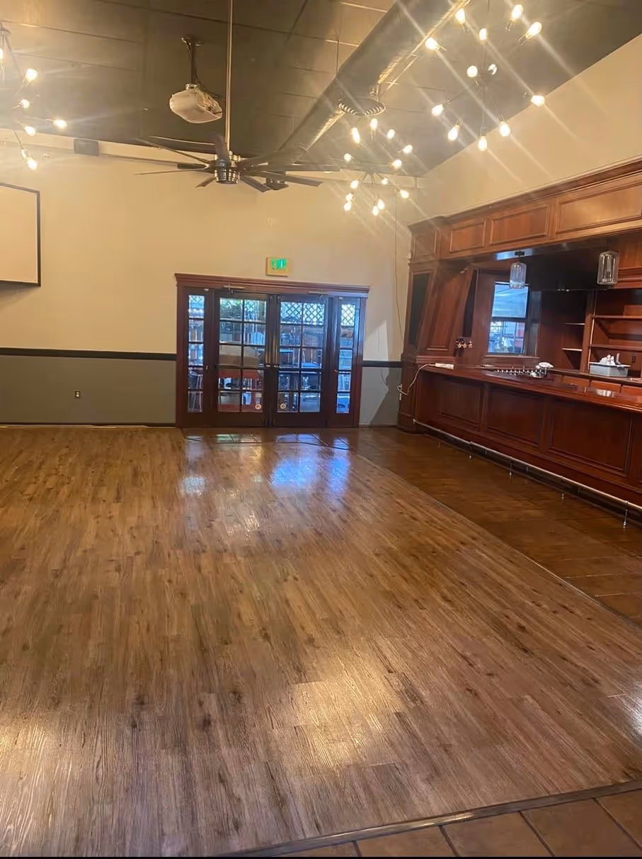 A refinished floor in a large room with a built-in bar