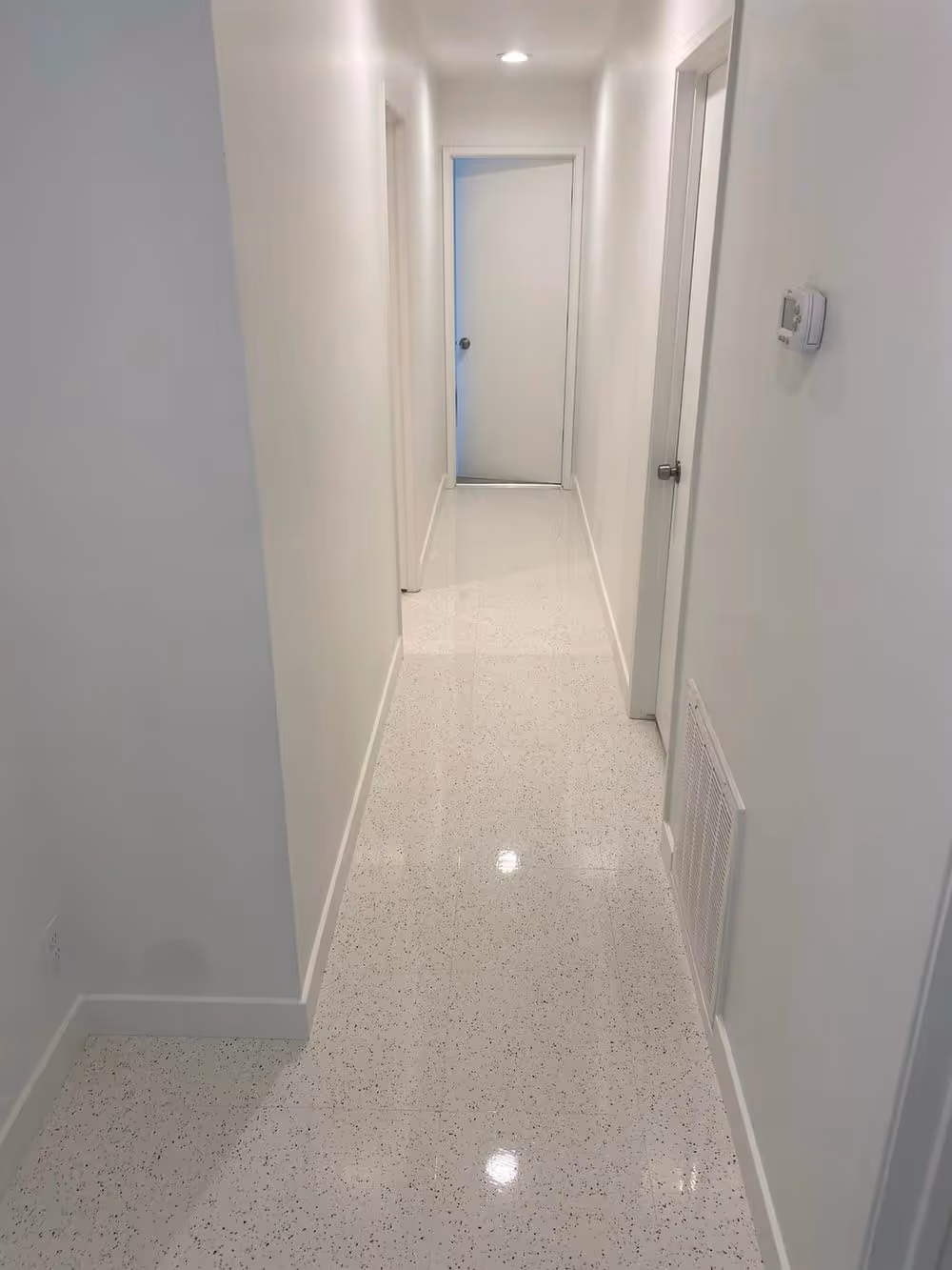 A white tile hallway cleaned end to end
